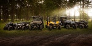 A line of Can-Am offroad vehicles in a forest